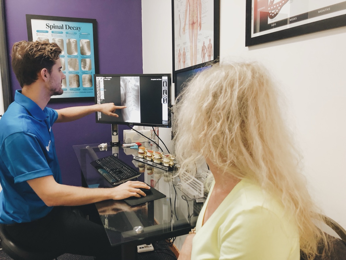 Chiropractor reviewing digital X-ray with patient at Absolute Health Mooloolaba